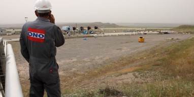 Larry Morrow, a construction supervisor for Norway's DNO Iraq, taking a call about work at the Tawke field as he overlooks the crude processing facility at DNO's Feyshkabour export center. On the far right is where Tawke field oil is piped in. To the left, pipelines running from a tanker offloading center where other KRG fields truck their crude to be exported. (BEN LANDO/Iraq Oil Report)