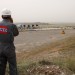 Larry Morrow, a construction supervisor for Norway's DNO Iraq, taking a call about work at the Tawke field as he overlooks the crude processing facility at DNO's Feyshkabour export center. On the far right is where Tawke field oil is piped in. To the left, pipelines running from a tanker offloading center where other KRG fields truck their crude to be exported. (BEN LANDO/Iraq Oil Report)