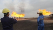 Iraqi South Oil Company engineers look toward the natural gas flares in the Zubair oil field in southern Iraq on January 21, 2010. (ESSAM AL-SUDANI/AFP/Getty Images)