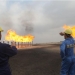 Iraqi South Oil Company engineers look toward the natural gas flares in the Zubair oil field in southern Iraq on January 21, 2010. (ESSAM AL-SUDANI/AFP/Getty Images)