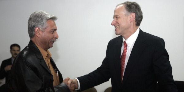 Vierbuchen, president of ExxonMobil Upstream Ventures, shakes hands with al-Ameedi, deputy director-general at PCLD, after signing a deal in Baghdad