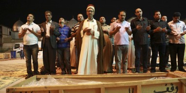 Mourners pray over the coffin of a victim killed in one of Monday's bomb attacks, during a funeral in Najaf