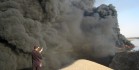 An Iraqi uses his mobile phone to take pictures of a burning oil pipeline running from the Baiji refinery on Sept. 18, 2007. (SABAH AL-BAZEE/Reuters)