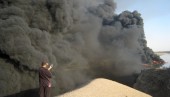 An Iraqi uses his mobile phone to take pictures of a burning oil pipeline running from the Baiji refinery on Sept. 18, 2007. (SABAH AL-BAZEE/Reuters)
