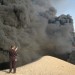 An Iraqi uses his mobile phone to take pictures of a burning oil pipeline running from the Baiji refinery on Sept. 18, 2007. (SABAH AL-BAZEE/Reuters)